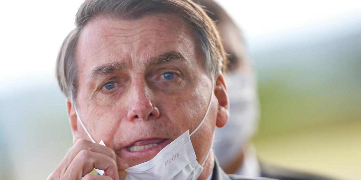 FILE PHOTO: Brazil's President Jair Bolsonaro adjusts his mask as he leaves Alvorada Palace, amid the coronavirus disease (COVID-19) outbreak in Brasilia, Brazil May 13, 2020. REUTERS/Adriano Machado TPX IMAGES OF THE DAY/File Photo