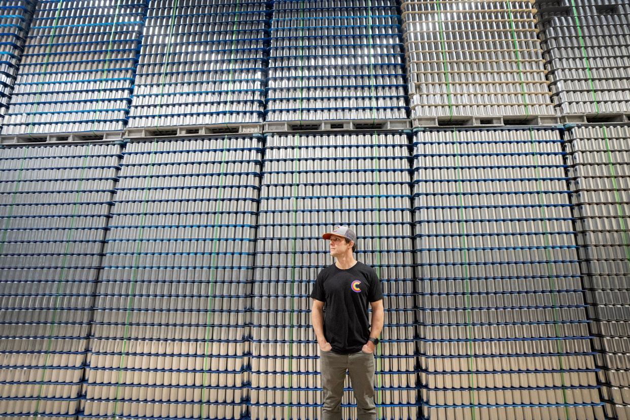 Co-owner Marshall Thompson stands near a few crates of blank aluminum cans while in the warehouse at Canworks Wednesday, Jan. 16, 2024. The facility prints branding artwork onto thousands of aluminum cans a day, helping businesses across the country.