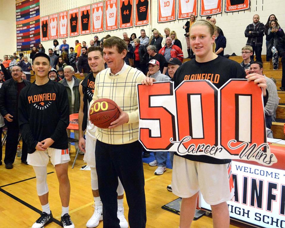 PLAINFIELD 12-16-2017 Bob Arremony, Plainfield High School boys basketball coach, is given a ball and a sign by team members Chris Peasley, right, Jarvin Alday, left, and Connor Davis after beating Montville for his 500th career win Saturday in Plainfield. See videos and more photos at NorwichBulletin.com [John Shishmanian/ NorwichBulletin.com]