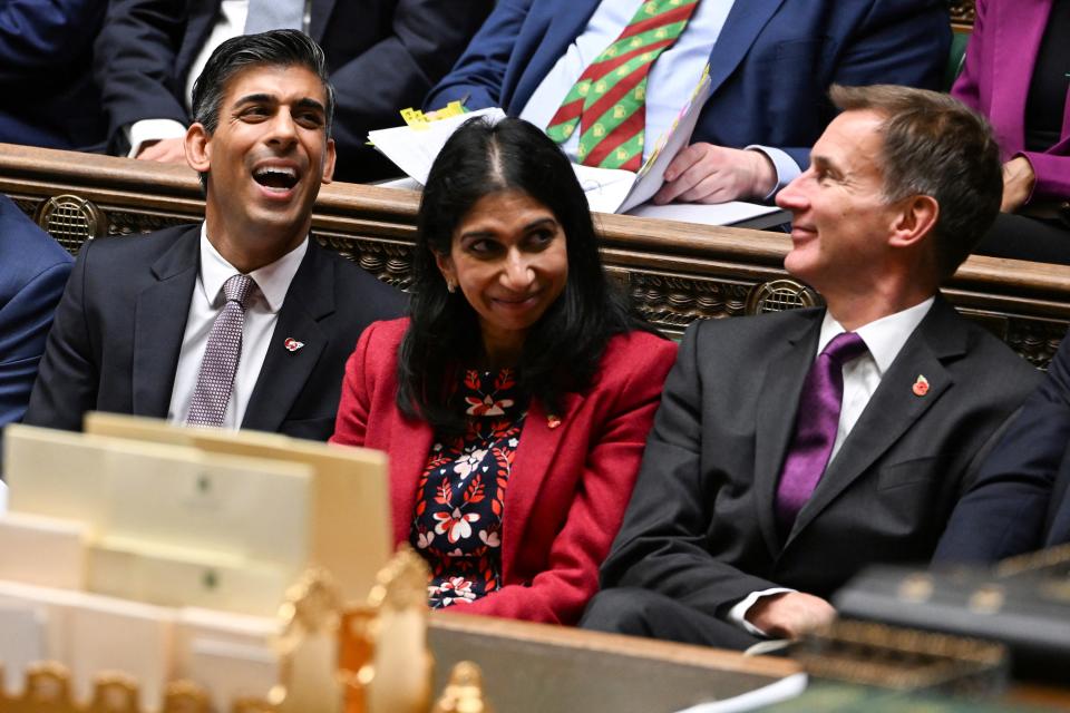 A handout photograph released by the UK Parliament shows Britain’s prime minister Rishi Sunak, home secretary Suella Braverman and chancellor Jeremy Hunt laughing during Prime Minister’s Questions (PMQs) in the House of Commons in London on 9 November 2022 (AFP via Getty Images)