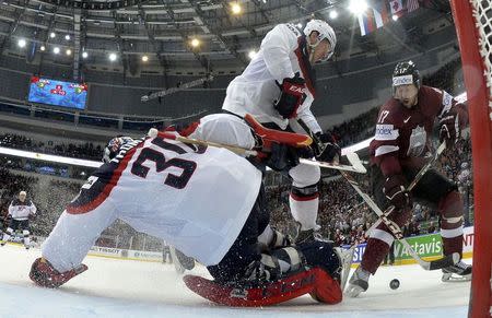 Goalie Tim Thomas and Matt Donovan of the U.S. are challenged by Latvia's Aleksandrs Nizivijs (L-R) during their men's ice hockey World Championship Group B game at Minsk Arena in Minsk May 15, 2014. REUTERS/Alex Kudenko/Pool