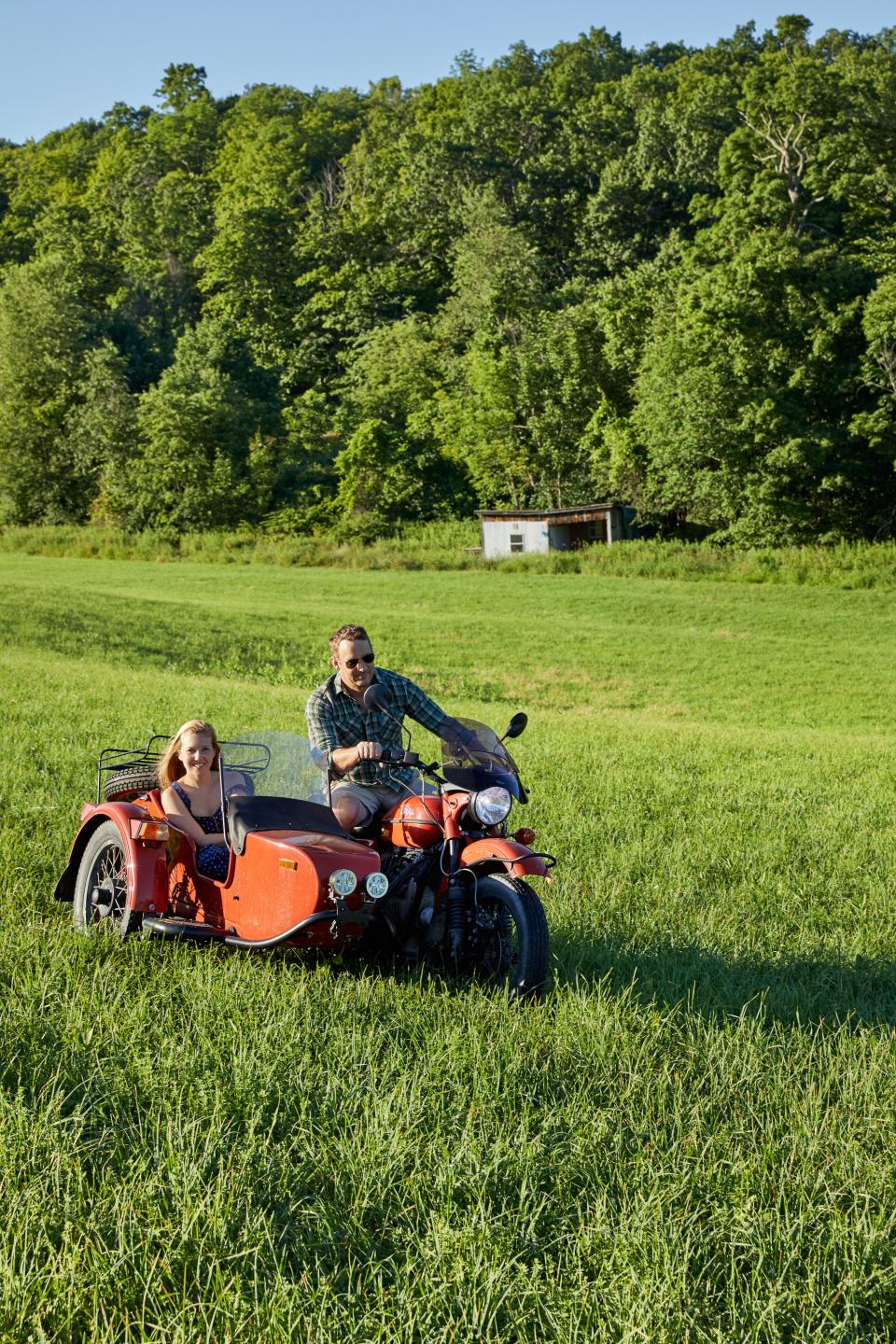 Graham and ten Have ride a motorcycle with sidecar on the property.