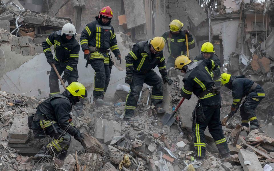 Firemen clear rubble and search for bodies after a Russian missile strike in central Kramatorsk - Julian Simmonds for The Telegraph