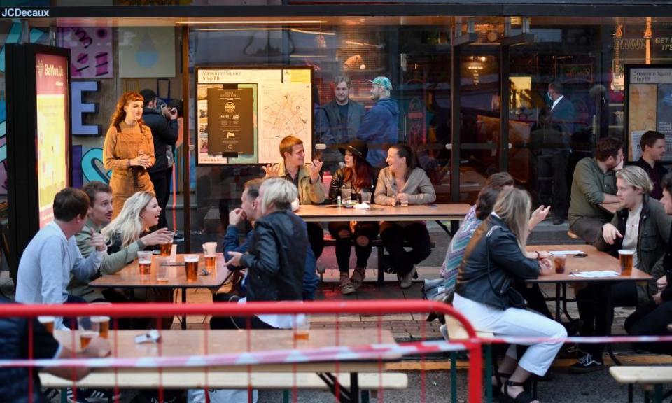 Customers drink in converted bus shelters in Manchester.