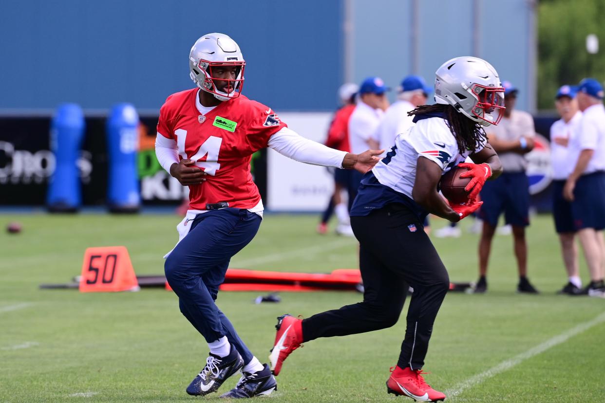 Patriots quarterback Jacoby Brissett (14) hands the ball to running back Rhamondre Stevenson (38) at minicamp at Gillette Stadium last month.