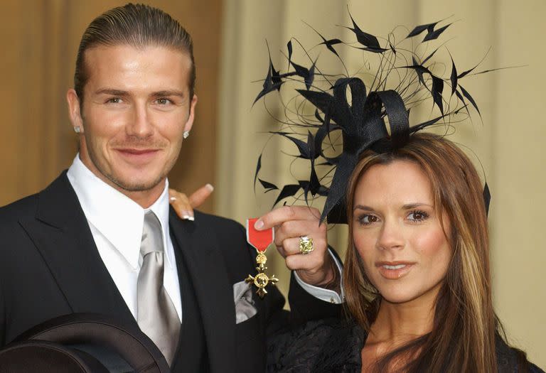 David Beckham, se encuentra con su esposa Victoria, mientras muestra el OBE (Oficial de la Orden del Imperio Británico) que recibió de manos de la Reina Isabel II de Gran Bretaña en el Palacio de Buckingham en noviembre 27 de 2003 en Londres