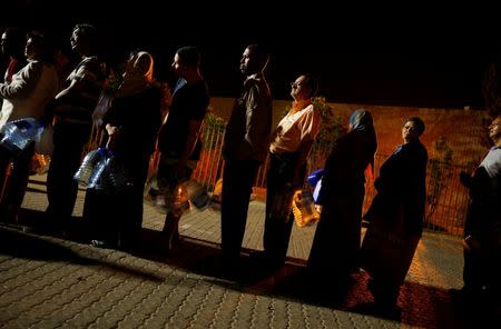 People queue to collect water from a spring as fears over the city's water crisis grow, in Cape Town's Newlands suburb, South Africa January 25, 2018. REUTERS/Mike Hutchings