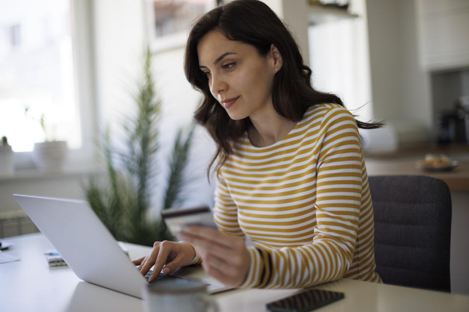 Woman makes an online payment to her credit card. (Credit: Getty Creative)