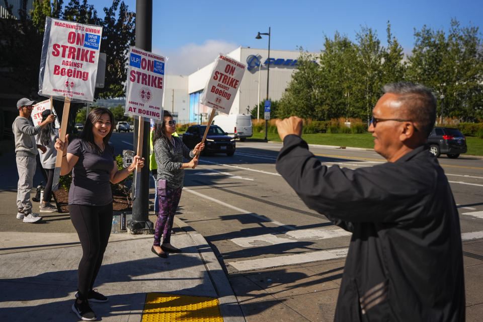 Boeing employee Dat Quach, right, who has worked for the company for 13 years as a mechanic, takes a photo of Huyen Nguyen, an intank sealer who has worked at Boeing for 14 years, as they work the picket line Tuesday, Sept. 24, 2024, outside the company's factory in Renton, Wash. (AP Photo/Lindsey Wasson)