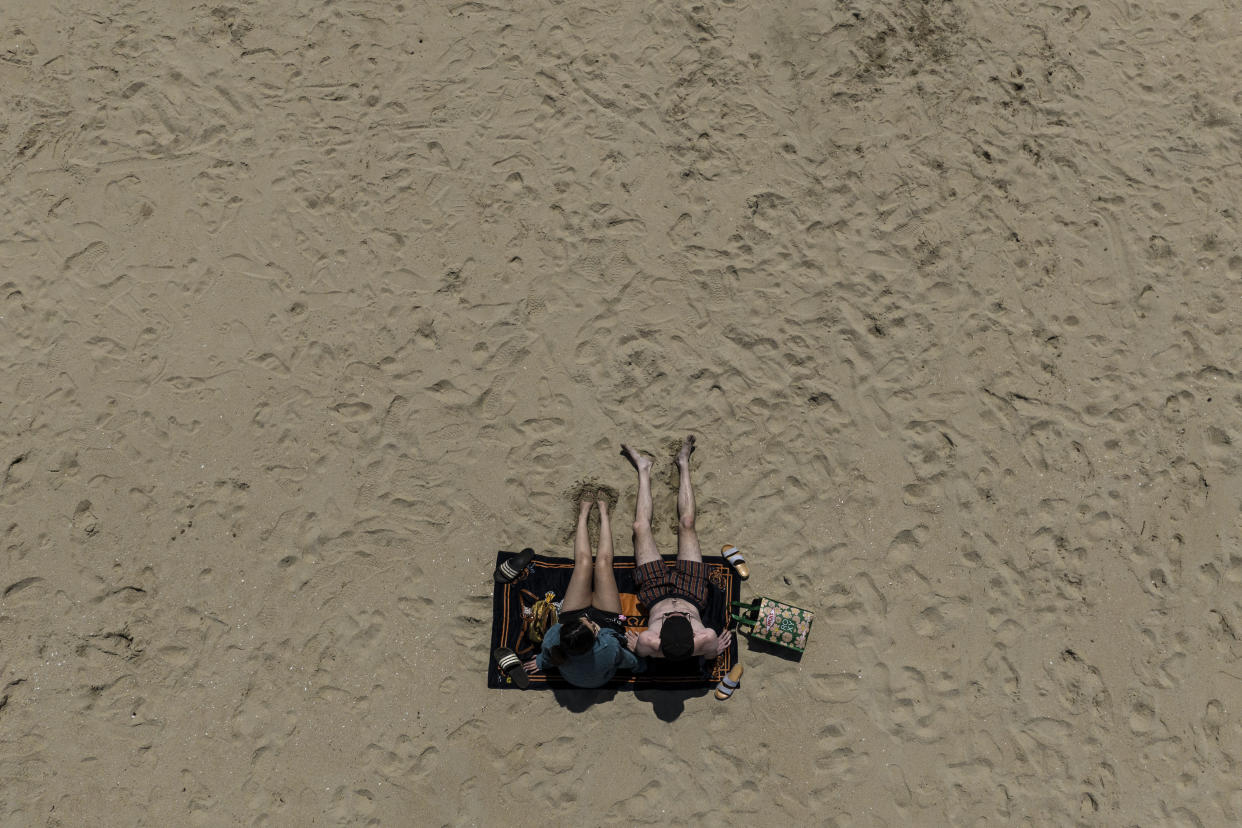 A young couple sunbathe on the beach in Huntington Beach, Calif., Monday, May 8, 2023. For years, studies have shown a decline in the rates of American high school students having sex. That trend continued, not surprisingly, in the first years of the pandemic, according to a recent survey by the Centers for Disease Control and Prevention. The study found that 30% of teens in 2021 said they had ever had sex, down from 38% in 2019 and a huge drop from three decades ago when more than half of teens reported having sex. (AP Photo/Jae C. Hong)