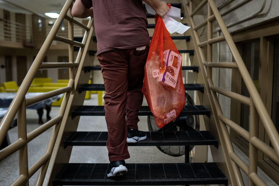 An inmate carries a bag of groceries to his cell in the "Little Scandinavia" unit.