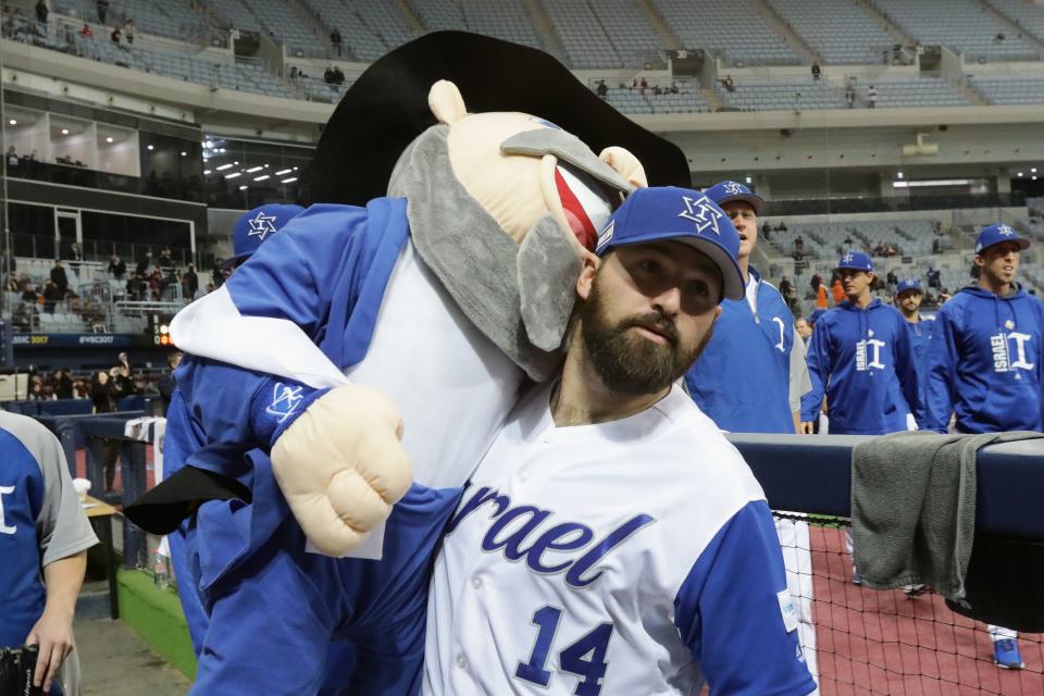 Cody Decker holds the Israel baseball team's mascot during the 2017 World Baseball Classic.