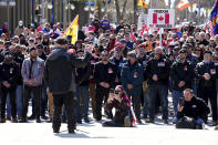 Participants gather to listen to a speaker at the National War Memorial during a demonstration, part of a convoy-style protest participants are calling "Rolling Thunder", in Ottawa, Saturday, April 30, 2022. (Sean Kilpatrick /The Canadian Press via AP)