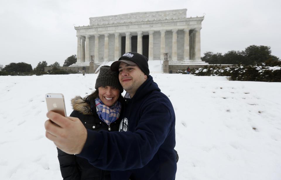 Couple takes a "selfie" at the snowy Lincoln Memorial in Washington