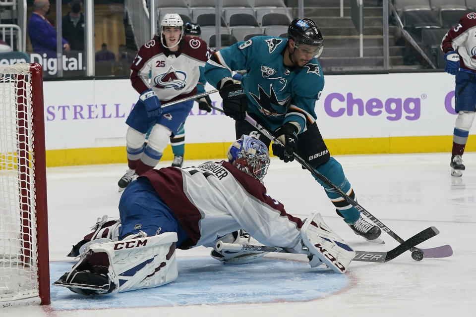 Colorado Avalanche goaltender Philipp Grubauer, bottom, defends a shot by San Jose Sharks left wing Evander Kane (9) during the third period of an NHL hockey game in San Jose, Calif., Monday, May 3, 2021. (AP Photo/Jeff Chiu)