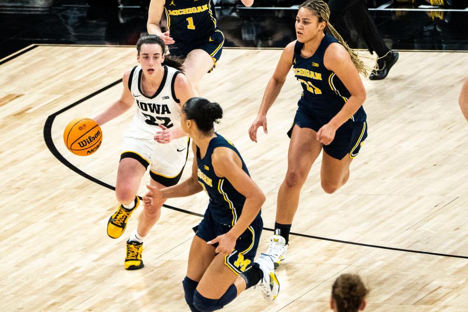 Michigan guard Laila Phelia (5) drives to the basket against Iowa guard Caitlin Clark (22) during the Big Ten Tournament semifinals at the Target Center on Saturday, March 9, 2024, in Minneapolis, Minn.