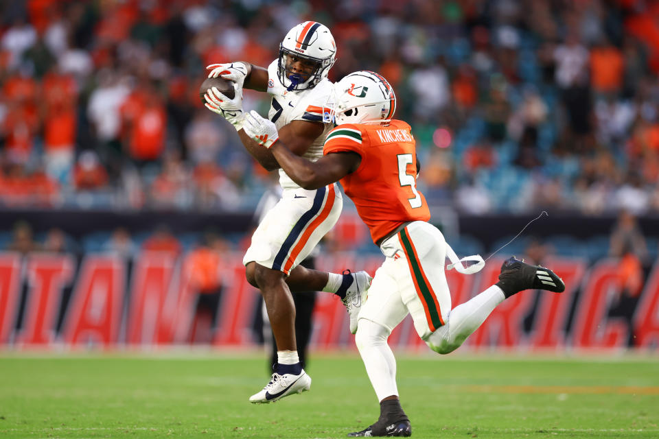 MIAMI GARDENS, FLORIDA – OCTOBER 28: Mike Hollins #7 of the Virginia Cavaliers catches a pass against Kamren Kinchens #5 of the Miami Hurricanes during overtime at Hard Rock Stadium on October 28, 2023 in Miami Gardens, Florida. (Photo by Megan Briggs/Getty Images)