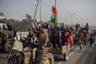 FILE - Protesting farmers ride tractors and shout slogans as they march to the capital breaking police barricades during India's Republic Day celebrations in New Delhi, India, Jan. 26, 2021. India’s parliament on Nov.29, 2021 repealed a set of controversial agriculture laws that inflamed tens of thousands of farmers, whose year-long protest has posed one of the biggest challenges to Prime Minister Narendra Modi’s administration. (AP Photo/Altaf Qadri, File)