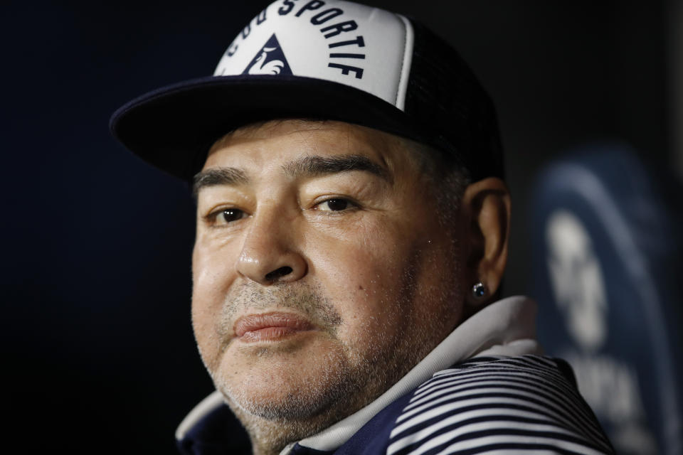 FILE - In this March 7, 2020 file photo, Diego Maradona, coach of Gimnasia y Esgrima, sits on the bench prior to Argentina's soccer league match against Boca Juniors at La Bombonera stadium in Buenos Aires, Argentina. Maradona turns 60 on Friday, Oct. 30, 2020. (AP Photo/Natacha Pisarenko, File)