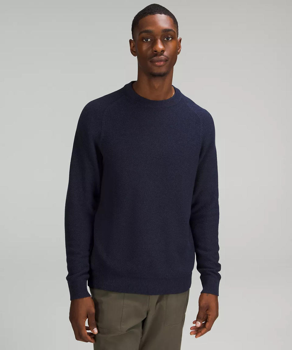 model wears navy blue Textured Knit Crewneck Sweater. Image via lululemon.