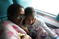 In this Sept. 5, 2018 photo, Venezuelan Sandra Cadiz listens to a voice message from her son Leonardo as she and her 10-year-old daughter Angelis take a bus from Cali to Ipiales, Colombia. After five days of walking and hitching rides they had gathered enough money from generous Colombians to begin buying bus tickets. The ride took them one border closer toward reaching Peru, where they hoped to reunite with Leonardo and his family. (AP Photo/Ariana Cubillos)