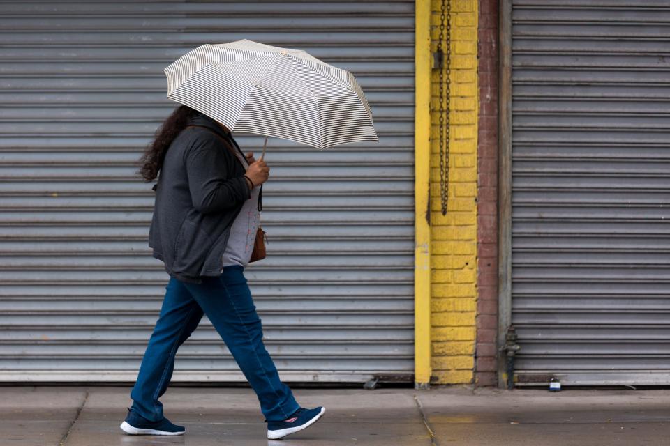 El Pasoans try to stay dry at the start of a rainy week in Downtown El Paso on Wednesday.