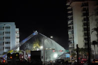 A Miami-Dade Fire Rescue team sprays water onto the rubble as rescue efforts continue where a wing of a 12-story beachfront condo building collapsed, late on Thursday, June 24, 2021, in the Surfside area of Miami.(AP Photo/Gerald Herbert)