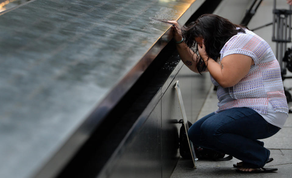 NEW YORK, NY - SEPTEMBER 11: Janice Lynch, of Queens, New York, pauses at the inscription of her friend Patricia Massani's name at the North Pool  for the memorial observances held at the site of the World Trade Center on September 11, 2014 in New York City. This year marks the 13th anniversary of the September 11th terrorist attacks that killed nearly 3,000 people at the World Trade Center, Pentagon and on Flight 93.  (Photo by Justin Lane - Pool/Getty Images)