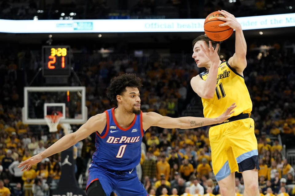 Marquette's Tyler Kolek (11) passes the ball past DePaul's Zion Cruz during the first half of an NCAA college basketball game Saturday, Feb. 25, 2023, in Milwaukee. (AP Photo/Aaron Gash)