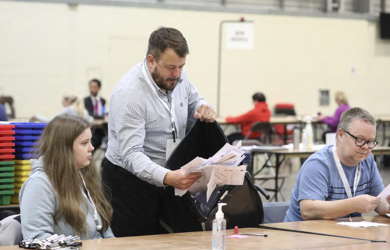 Ballot boxes are emptied at Peterborough Arena, as counting begins across the UK for the local government elections, in Peterborough, England, Thursday, May 5, 2022. (Paul Marriott/PA via AP)