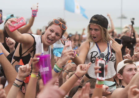 Women take a selfie at a concert by country music super star Luke Bryan during spring break festivities in Panama City Beach, Florida March 12, 2015. Like previous Florida spring break hot spots Fort Lauderdale and Daytona Beach, Panama City Beach is facing a crisis of conscience over the trade-offs involved in hosting a binge for some 300,000 students who arrive through mid-April with coolers, beer funnels and credit cards. REUTERS/Michael Spooneybarger