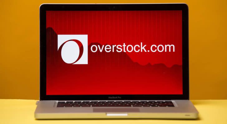 Image of overstock.com (OSTK) logo on a laptop with a plain yellow background.