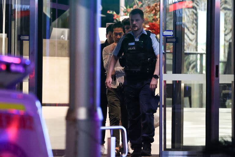 Un agente policial escoltando a las personas que se encontraban dentro del centro comercial