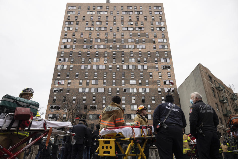 Personal de emergencias trabaja frente a un edificio de apartamentos que se incendió en el distrito del Bronx, el domingo 9 de enero de 2022, en la ciudad de Nueva York. (AP Foto/Yuki Iwamura)