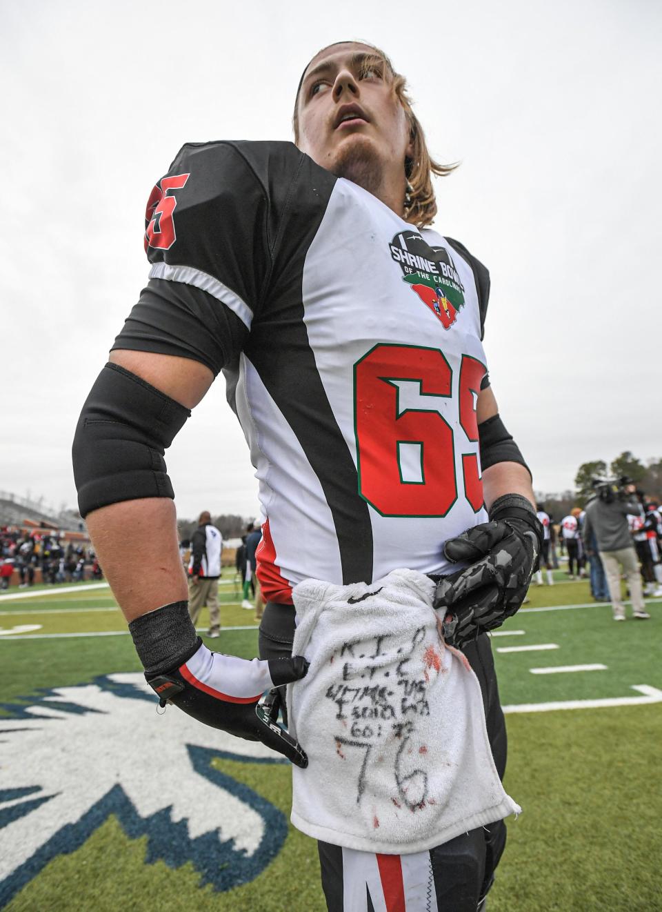 South Carolina offensive lineman Jake Buerk of Gaffney High wears a towel with RIP and Isaiah 60:22, celebrating with teammates after the Shrine Bowl of the Carolinas football all star game at Viking Stadium in Spartanburg, S.C. Saturday, December 16, 2023. South Carolina won 24-0.