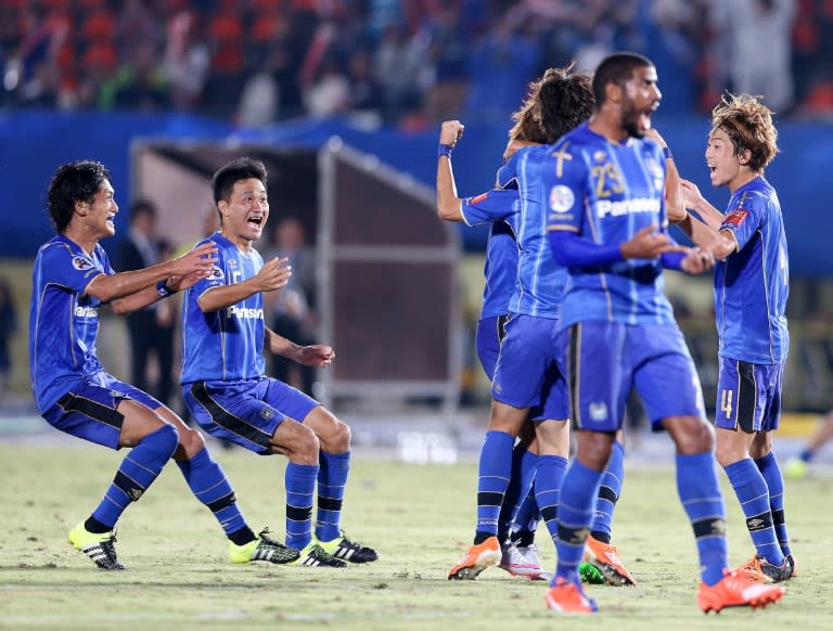 Japan's Gamba Osaka players celebrate their victory over South Korea's Jeonbuk Hyundai Motors during the football quarter-final of the AFC champions league in Osaka on September 16, 2015