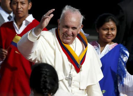 El papa Francisco saluda vistiendo una faja con los colores de Ecuador a su llegada a Quito. 5 de julio de 2015. Francisco llamó el domingo a valorar las diferencias y fomentar el diálogo para lograr que los progresos sociales de Ecuador beneficien a todos, en la primera escala de una gira por tres de los países que más sufren por la pobreza en Sudamérica. REUTERS/Jose Miguel Gomez