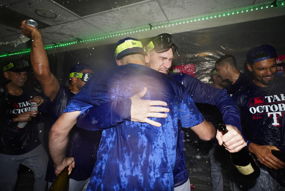 The Texas Rangers celebrate clinching a playoff spot in the American League after a 6-1 win over the Seattle Mariners in a baseball game, Saturday, Sept. 30, 2023, in Seattle. (AP Photo/Lindsey Wasson)