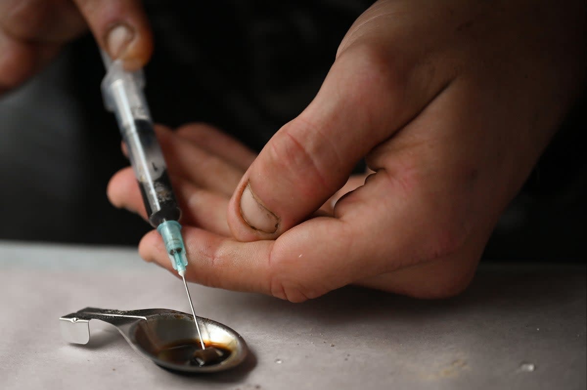 Drug users prepare heroin before injecting at an overdose prevention centre set up in Glasgow by activist Peter Krykant in 2020  (Jeff J Mitchell/Getty Images)