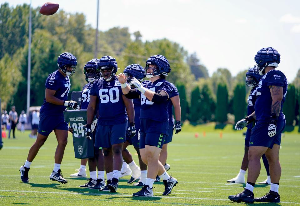 Seattle Seahawks center Evan Brown tosses a ball as guard Phil Haynes (60) and other defensive players watch during the NFL football team's training camp Wednesday, July 26, 2023, in Renton, Wash. (AP Photo/Lindsey Wasson)
(Credit: Lindsey Wasson, AP)