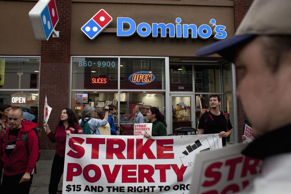 Demonstrators are pictured in front of Domino's Pizza during a strike aimed at the fast-food industry and the minimum wage in Seattle, Washington