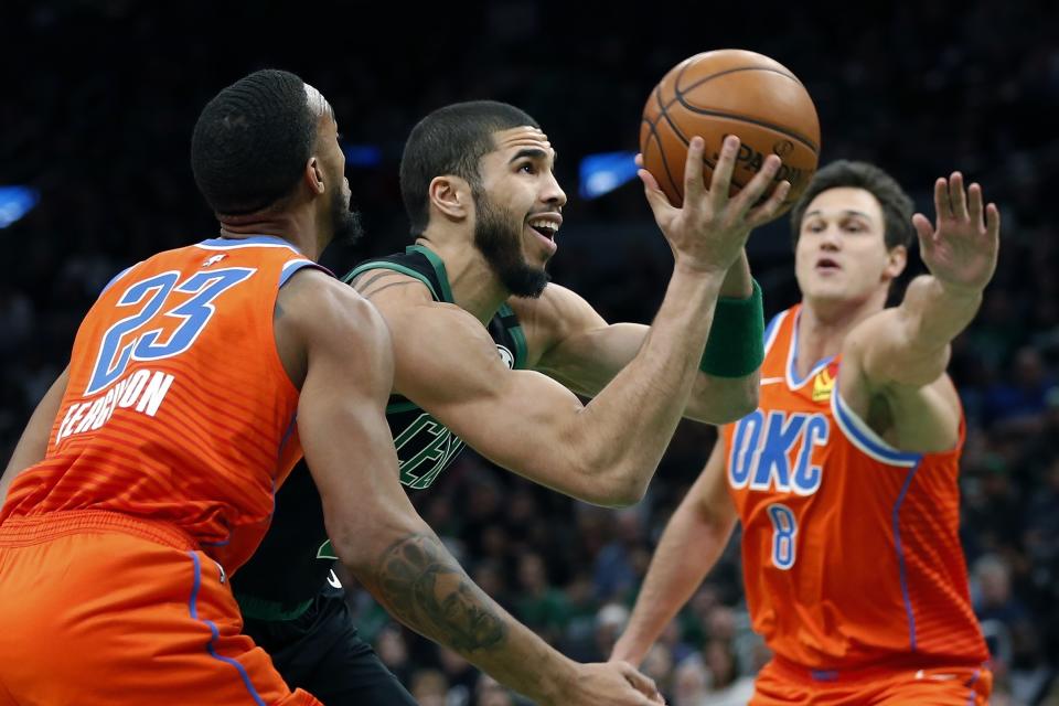 Boston Celtics' Jayson Tatum drives for the basket against Oklahoma City Thunder's Danilo Gallinari (8) and Terrance Ferguson (23) during the first half of an NBA basketball game, Sunday, March, 8, 2020, in Boston. (AP Photo/Michael Dwyer)