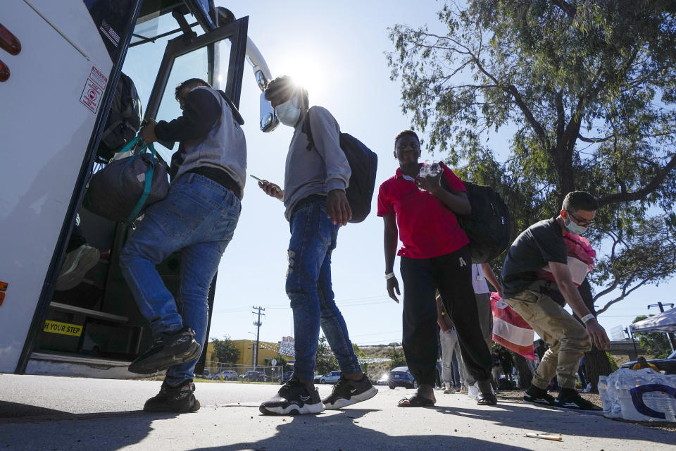 Migrants board a bus to the airport Friday, Oct. 6, 2023, in San Diego. San Diego's well-oiled system of migrant shelters is being tested like never before as U.S. Customs and Border Protection releases migrants to the streets of California's second-largest city because shelters are full. (AP Photo/Gregory Bull)