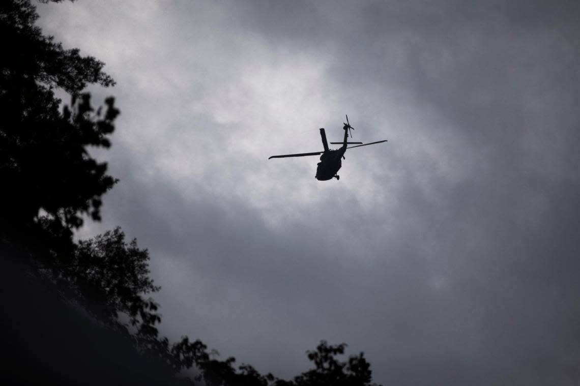 A search and rescue helicopter flies over Troublesome Creek and KY-476 in Breathitt County, Ky., Sunday, July 31, 2022.