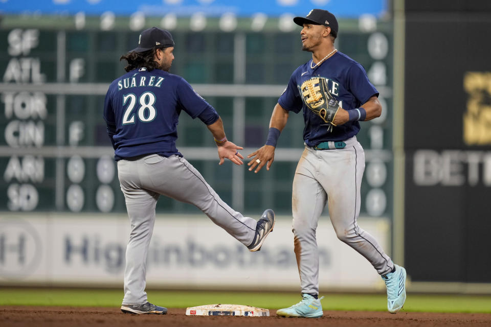 Seattle Mariners center fielder Julio Rodriguez, right, celebrates with third baseman Eugenio Suarez, left, after their win over the Houston Astros in a baseball game, Friday, Aug. 18, 2023, in Houston. (AP Photo/Eric Christian Smith)