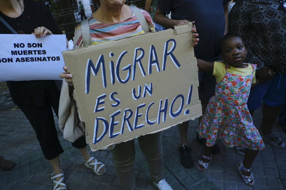A woman holds up a banner that reads: "Migration is a right", during one of many protests across Spain amid for the investigation over the deaths of at least 23 people at the border between the Spanish enclave of Melilla and Morocco, in Pamplona, northern Spain, Friday, July 1, 2022. (AP Photo/Alvaro Barrientos)