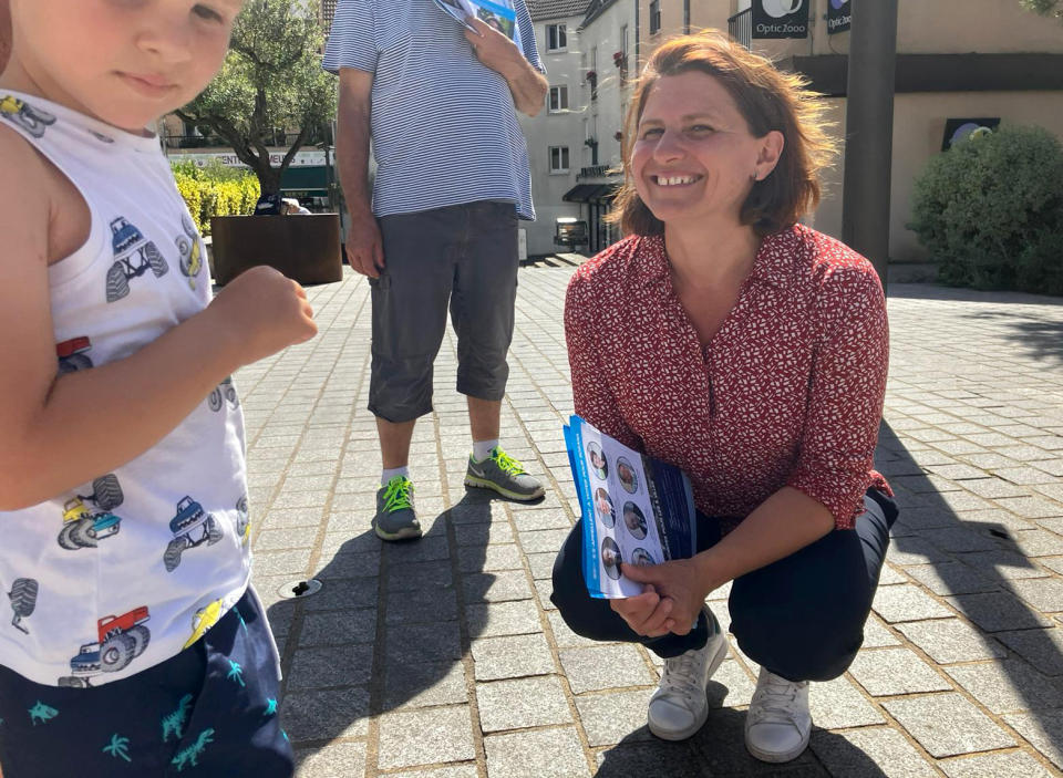 Roxana Maracineanu smiles to a child as she campaigns ahead the parliamentary elections' decisive round, Thursday, June 16, 2022 in Thiais, south of Paris. Born in Romania, Maracineanu arrived in France with her family in 1984, and became the first world champion in French swimming history and silver medalist at the 2000 Sydney Olympics. She faces former chambermaid Rachel Keke, a Black woman who fought for the rights of her hotel chambermaids co-workers has become the symbol of the recent revival of the French left. (AP Photo/Alexander Turnbull)