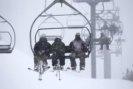 Skiers ride up a chair lift as snow falls on Mammoth Mountain in California November 9, 2015 in this handout photo provided by Mammoth Mountain Ski Area Monday. REUTERS/Kevin Westenbarger/Mammoth Mountain Ski Area/Handout via Reuters