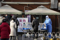 A medical worker in protective gear push a stretcher with a plastic enclosure outside a fever clinic at a hospital in Beijing, Friday, Dec. 9, 2022. China began implementing a more relaxed version of its strict "zero COVID" policy on Thursday amid steps to restore normal life, but also trepidation over a possible broader outbreak once controls are eased. (AP Photo/Ng Han Guan)
