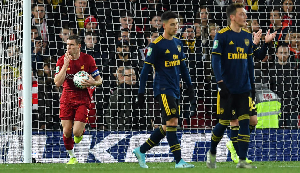 Liverpool's English midfielder James Milner (L) passes Arsenal's Brazilian striker Gabriel Martinelli (C) as he celebrates scoring his team's second goal, from the penalty spot during the English League Cup fourth round football match between Liverpool and Arsenal at Anfield in Liverpool, north west England on October 30, 2019. (Photo by Paul ELLIS / AFP) / RESTRICTED TO EDITORIAL USE. No use with unauthorized audio, video, data, fixture lists, club/league logos or 'live' services. Online in-match use limited to 75 images, no video emulation. No use in betting, games or single club/league/player publications. /  (Photo by PAUL ELLIS/AFP via Getty Images)